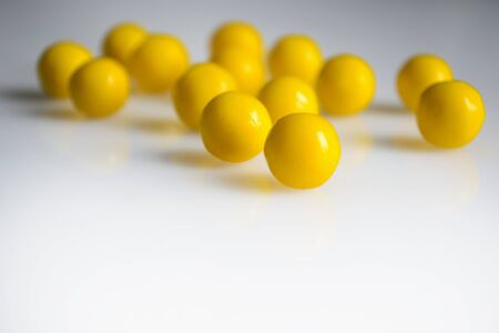 yellow round pills vitamins bada on white table close up