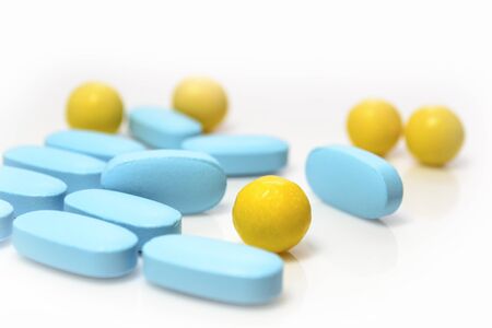 blue, yellow pills on a white background close-upの写真素材