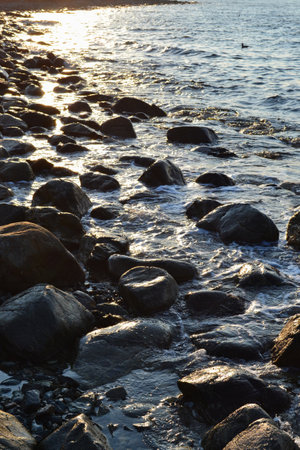 large sea stones washed by the waves and the sunsetの写真素材