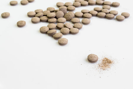 colored pills of vitamins, dietary supplements on a white table close-upの写真素材