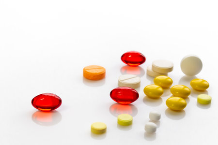 multi-colored pills of vitamins, dietary supplements on a white table close-upの写真素材