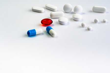 multi-colored pills of vitamins, dietary supplements on a white table close-upの写真素材