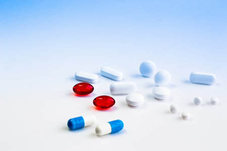 multi-colored pills of vitamins, dietary supplements on a white table close-upの写真素材