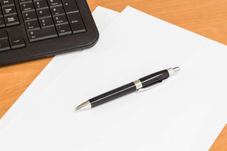 keyboard piece of paper and pen on the tableの写真素材