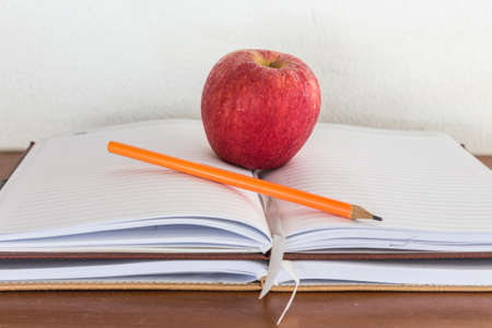red apple on open heavy bookの写真素材