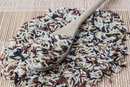 Long grain rice,brown rice, with wooden spoonの写真素材
