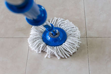 mop cleaning a floor from dustの写真素材