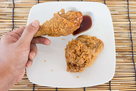 fried chicken with sauce on white plateの写真素材