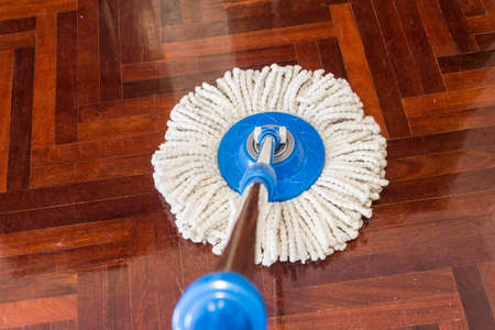 mop cleaning wooden floor from dustの写真素材