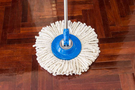 mop cleaning wooden floor from dustの写真素材