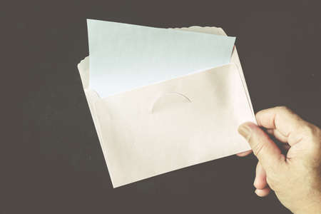 Hand hold a envelope and paper on  black backgroundの写真素材