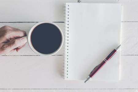 Black coffee with notebook and pen on wooden backgroundの写真素材