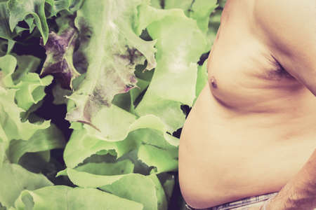 Fat man and vegetable backgroundの写真素材