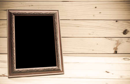 Photo frame on wooden background - Vintage tone