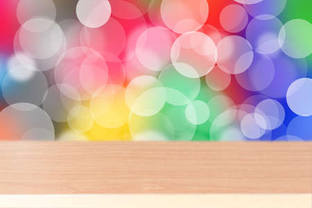 Wood table top on colorful background with defocused lightsの写真素材