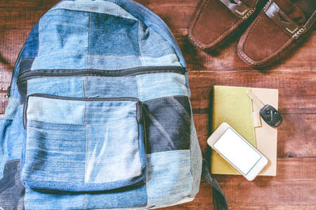 Top view backpack, smartphone, car key and book on wooden backgroundの写真素材