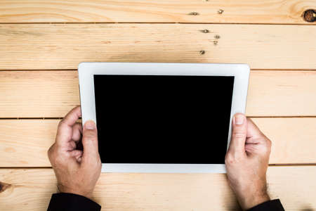 Businessman with tablet pc computer  on wooden tableの写真素材