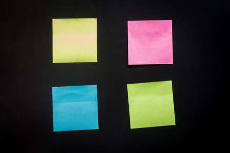 Reminder sticky note on black background, empty space for textの写真素材