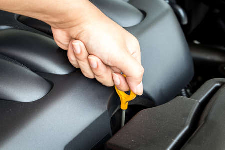 Auto mechanic checking oil