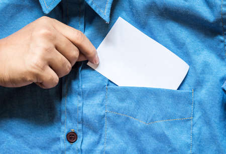 Hand with blank white card with copy space in a pocket of shirtの写真素材