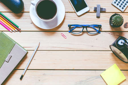 Office supplies and coffee cup on  wooden table with copy spaceの写真素材