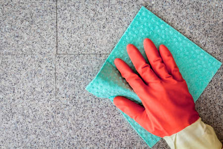 Hand and a blue cloth cleaning on a  wallの写真素材