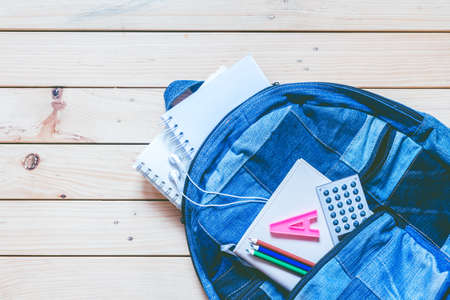 Backpack with school supplies on wooden backgroundの写真素材