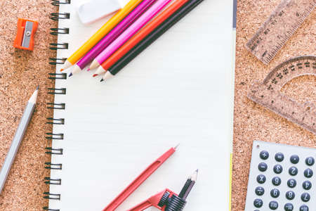 School supplies on the background of the cork boardの写真素材