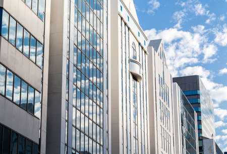 Office buildings against blue sky with clouds and sun light