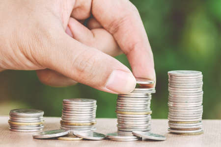 Male hand putting money coin like stack growing business - finance and money conceptの写真素材