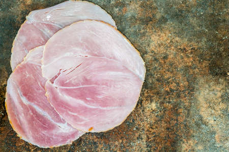 Sliced smoked ham on stone backgroundの写真素材