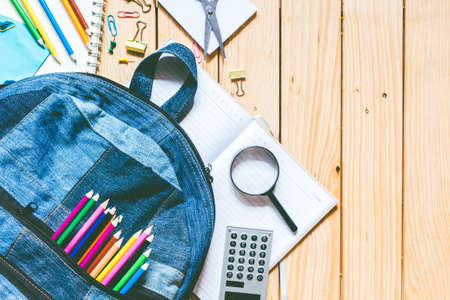 Backpack with school supplies on wooden backgroundの写真素材