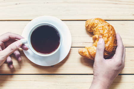 Coffee and croissant for breakfast on wooden tableの写真素材