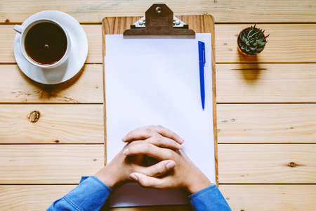 Hands working in the office with documents on wooden tableの写真素材