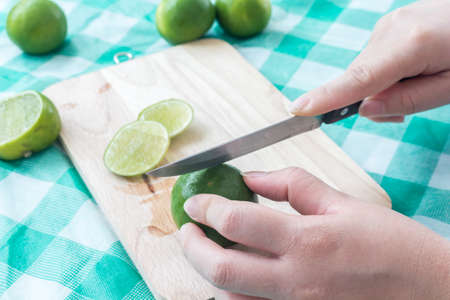 Woman cutting a slice of lime in piecesの写真素材