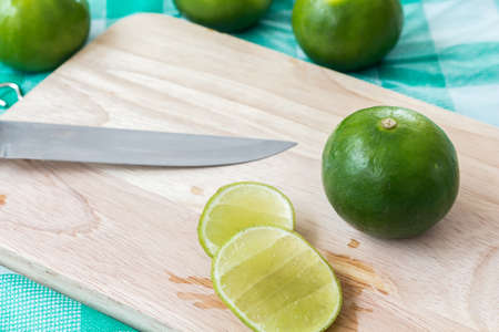Pieces of lime on wooden cutting boardの写真素材