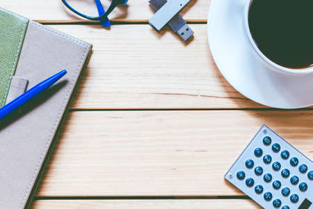 Office supplies and coffee cup on  wooden table with copy spaceの写真素材