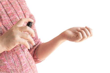 Young woman applying perfume on her wrist isolated on white background