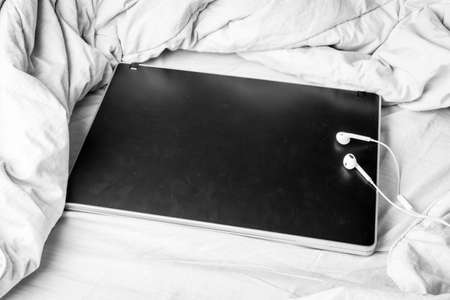 Black laptop on the bedの写真素材