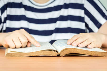 Woman reading book on the tableの写真素材