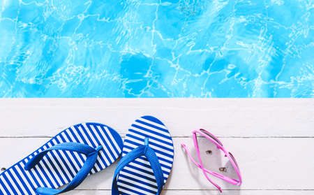 flip-flops and sunglasses on the swimming pool