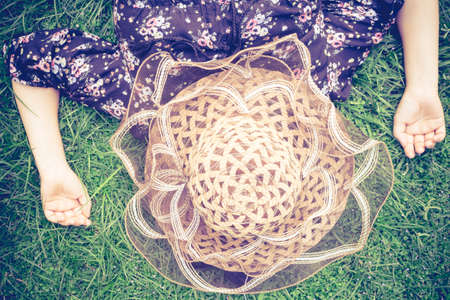 Woman lying on grass with her hat