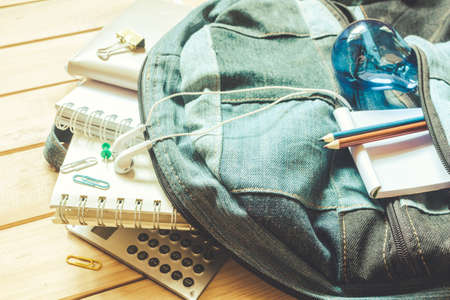 Backpack with school supplies on wooden backgroundの写真素材