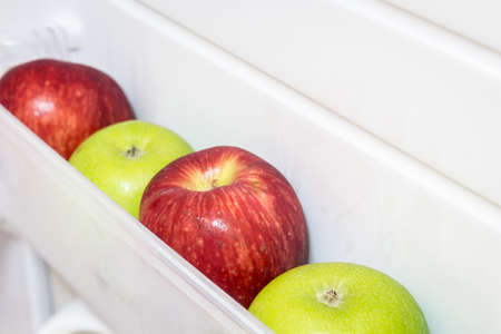 Apple in open empty refrigerator ideal for dietの写真素材