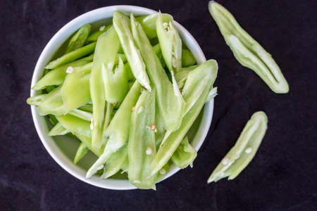 Fresh green bell pepper cooking on black background