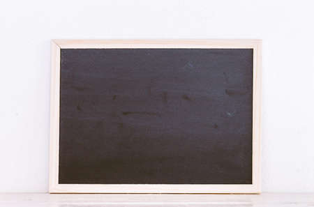 Wooden framed blank blackboard  on wooden table