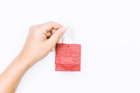 Hands holding a empty red paper bag on white backgroundの写真素材