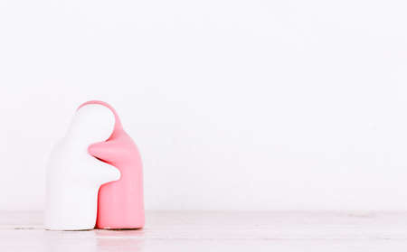 Ceramic toys is hugging on wooden tableの写真素材