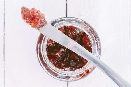 Strawberry jam in a jar on wooden table