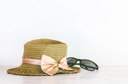 Hat and sunglasses on wooden table